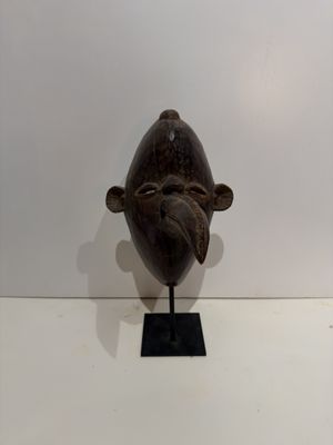 sculpture of a fish on a black stand on a white surface