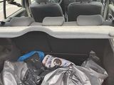the back of a car with a bag of garbage in it ' s trunk