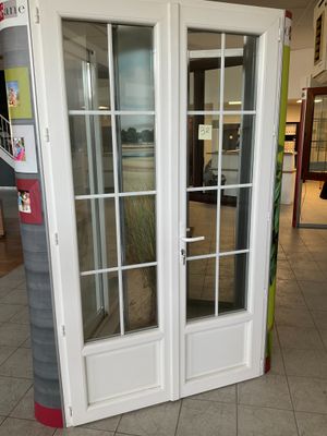 une double porte blanche avec une vitre dans un magasin