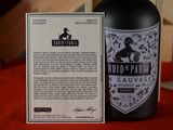 a bottle of wine sitting next to a card on a table