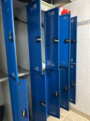 Plusieurs casiers bleus sont alignés les uns à côté des autres dans une salle de bains