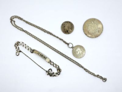 several silver jewelry items including a necklace, bracelet, and a coin