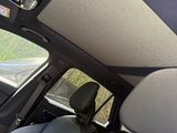 l'intérieur d'une voiture avec le toit ouvrant baissé et une vue sur la route