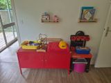 une armoire rouge dans la pièce, sur laquelle sont posés des jouets
