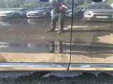 a reflection of a man standing in the reflection of a car door