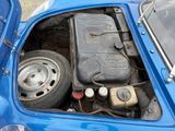 a blue car with an engine in the trunk of it