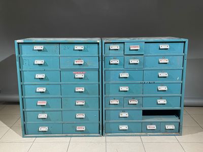 une paire de classeurs bleus portant des étiquettes, dans une pièce