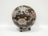 a vase with flowers on it sitting on a stand