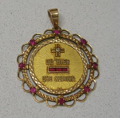 une médaille d'or ornée d'une croix sur un fond blanc