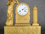 une horloge en or surmontée d'une statue