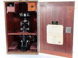 une boîte en bois sur laquelle est posé un microscope