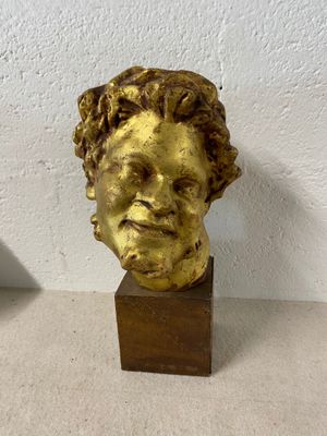 statue of a man ' s head on a wooden base