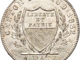 a silver coin with a shield and laurel on it