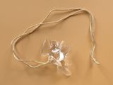 a clear plastic object on a string on a brown surface