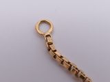 an image of a close up of a gold chain on a white surface