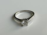 une image d'une bague en diamant sur une surface blanche