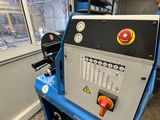 un homme debout à côté d'une machine dans une pièce