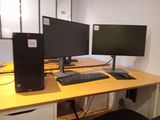 two computer monitors and a keyboard on a desk