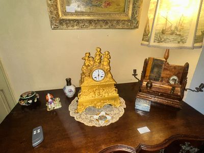 a gold clock sitting on top of a wooden desk