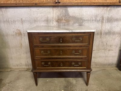 a marble top chest of drawers in a room