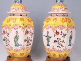 pair of yellow and white vases with asian figures on them