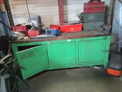 une armoire verte dans un garage, avec des outils posés sur le plan de travail