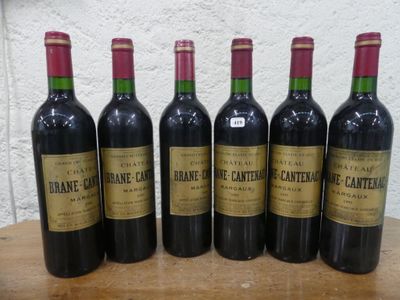 six bouteilles de vin sont alignées sur une table en bois