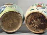 pair of chinese vases with floral designs on them sitting on a white surface