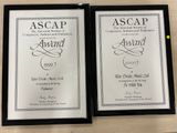 two framed awards on a table with a yellow ball