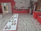 a picture of a room that has a long table with vases on it