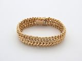 un bracelet à chaîne en or avec un fermoir sur fond blanc