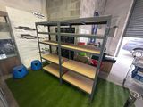 a room with shelves and a green carpet in it