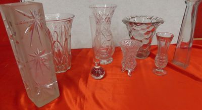 a lot of glass vases and glasses on a table