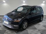 La Volkswagen Touran noire est garée dans une pièce au sol en damier.