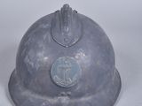 un casque métallique orné d'un emblème bleu