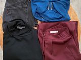 three pairs of men ' s pants sitting on top of a wooden table