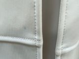 a close up of a white leather jacket with a zipper