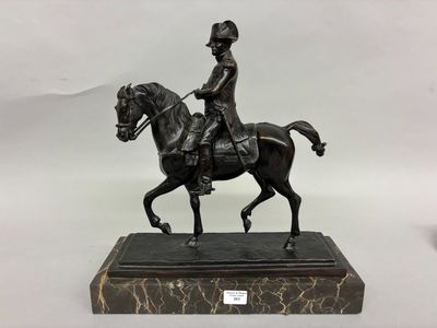 bronze statue of a man riding a horse on a marble base