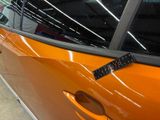 an orange car that has a sticker on the side of it