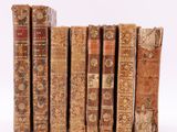 plusieurs vieux livres sont alignés sur une surface blanche