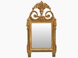 un miroir avec un cadre doré, sur lequel est posé un vase