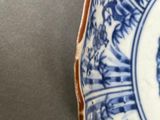 a blue and white plate with a picture of a man on it