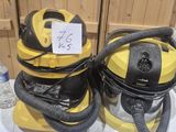 two yellow and black vacuums sitting on top of a counter