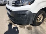 a white van parked in a parking lot with a shadow on the ground