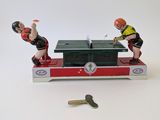 two figurines of men playing ping pong on a table