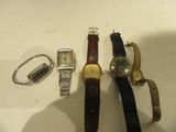 trois montres et un porte-clés posés côte à côte sur une table