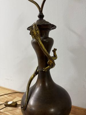 une lampe posée sur une table, sur laquelle se trouve un lézard