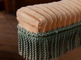 a wooden bench with a green and tan blanket on it