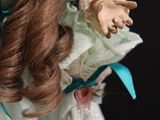 a close up of a doll with long brown hair