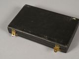 a small black box with gold handles on a table